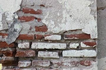 close up of the walls of an old house made of red brick which are porous and peeling so you can see...