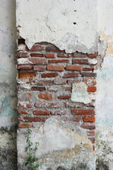 close up of the walls of an old house made of red brick which are porous and peeling so you can see the details of the inside. Lacks maintenance and ages
