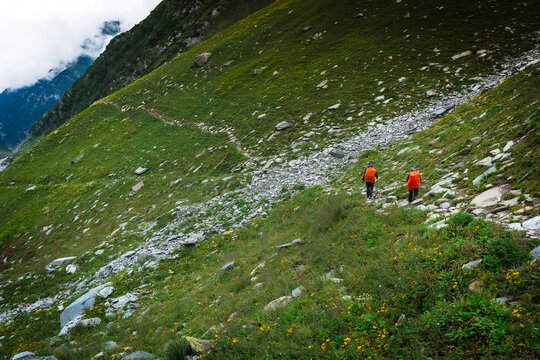 Group of trekkers with hiking backpacks on beautiful mountain landscape background. Climbers hike to mountains. Group of hikers walking in mountains	