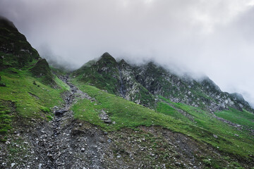 Beautiful landscape shot of a gorgeous Himalayan mountain valley with dense forests during monsoon season	
