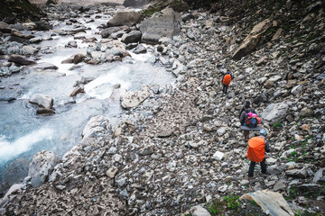 Group of trekkers with hiking backpacks on beautiful mountain landscape background. Climbers hike to mountains. Group of hikers walking in mountains 