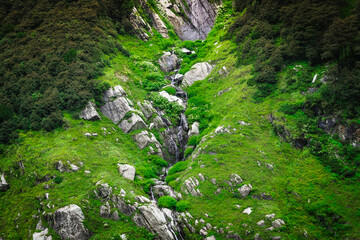 Beautiful landscape shot of a gorgeous Himalayan mountain valley with dense forests during monsoon season	
