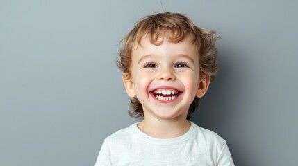Happy Young Child with Bright Smile Posing Against Gray Background