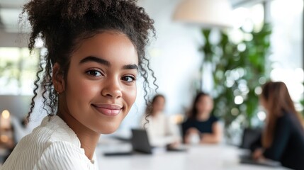A diverse group of four professionals is engaged in a collaborative meeting in a modern office space.
