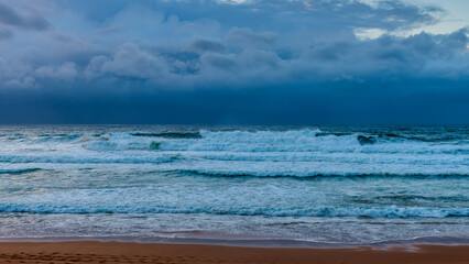 Moody sunrise with waves at the seaside