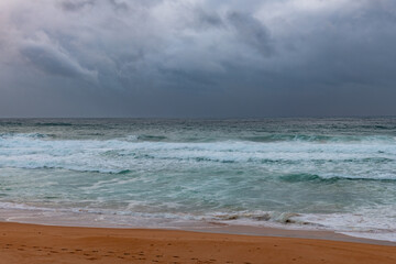 Moody sunrise with waves at the seaside