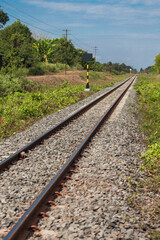 Fototapeta premium Train tracks stretching through lush landscape in rural area captured in vibrant daylight scenic viewpoint