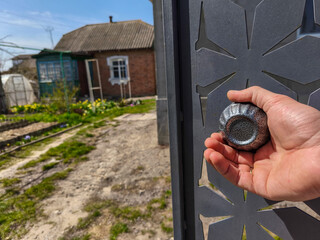 Naklejka premium A person holding a small object in their hand in front of a gate