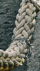 Detailed close-up of a thick, weathered rope, showcasing its texture and ruggedness