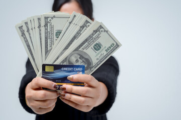 Young woman holding banknotes and credit cards