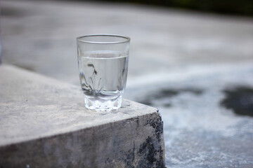 water in a glass on a cement floor isolated Bokeh background