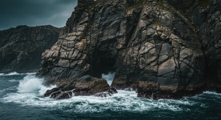 Obraz premium Dark Grey Rocks and Powerful Ocean Waves Crashing on Rugged Coast