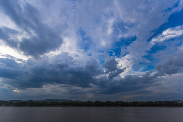 Obraz premium Dramatic cloud formation over serene river nature photography open landscape scenic view atmospheric conditions