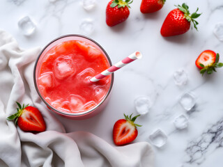 Refreshing strawberry juice with ice cubes and striped straw on marble table