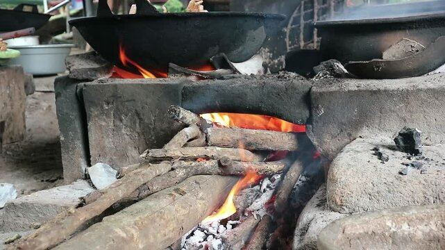 Close up of cooking using firewood as the main fuel on a traditional stove in an old kitchen in the village.

