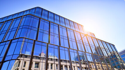 Modern office building with glass facade on a clear sky background. Transparent glass wall of office building.