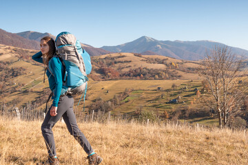 Naklejka premium Travel concept and background. Defocused tourist with backpacking on foreground and panoramic alpine scenery.