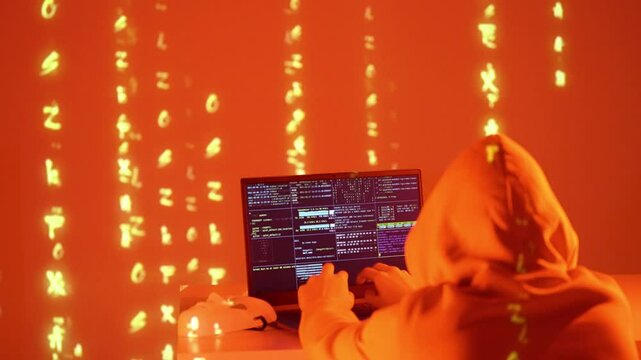 A mysterious hacker types rapidly in a glowing blue room, surrounded by cascading digital symbols. A white mask lies beside them, symbolizing anonymity in the world of cyber exploits