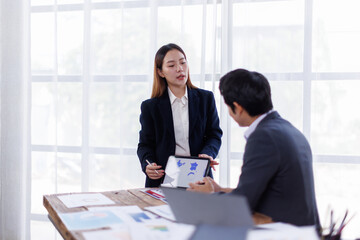 Team of financial advisory services. Asian advisor showing plan of investment to clients in the consultancy office.
