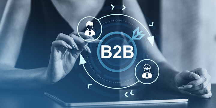 Businesswoman interacting with B2B network interface on digital tablet with creative blue background and futuristic communication concept..