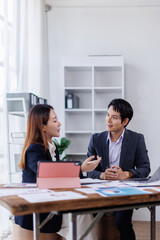 Team of financial advisory services. Asian advisor showing plan of investment to clients in the consultancy office.
