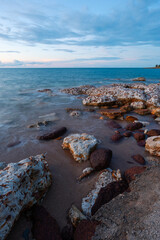 Sunset view of rocky seascape beach coastline.
