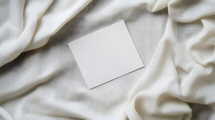 A blank card rests on soft, beige fabric, inviting creativity and personalization.