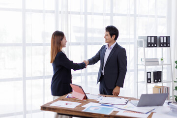 Happy two Asian business man and woman handshake to congratulate success. Successful Asian business people working together team.

