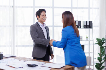 Happy two Asian business man and woman handshake to congratulate success. Successful Asian business people working together team.
