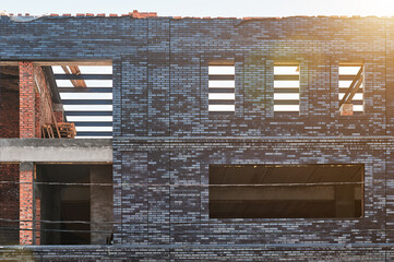 facade of a building under construction made of gray brick