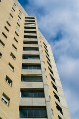 upward perspective of a brutalist building, highlighting its structure and design under a dramatic sky.