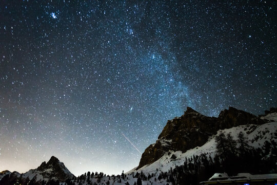 Milky way over peak in the Dolomites in winter, Italy