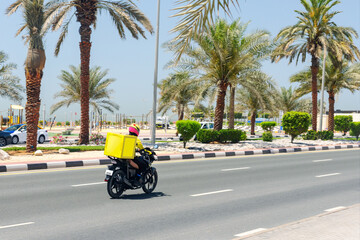 Couriers of online food ordering company  in the afternoon in the city, UAE.