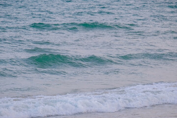 Gentle waves roll onto shore creating serene atmosphere perfect for summer beach getaway