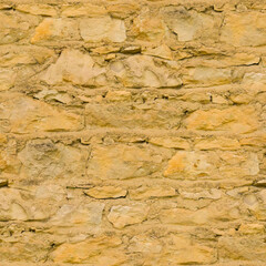 An old yellow wall made of stone and cement. Yellow, stone background. Ancient ruins. Stone texture. Seamless image.