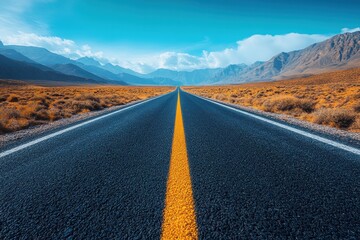 Endless road stretches through mountainous landscape under a clear blue sky during daylight hours