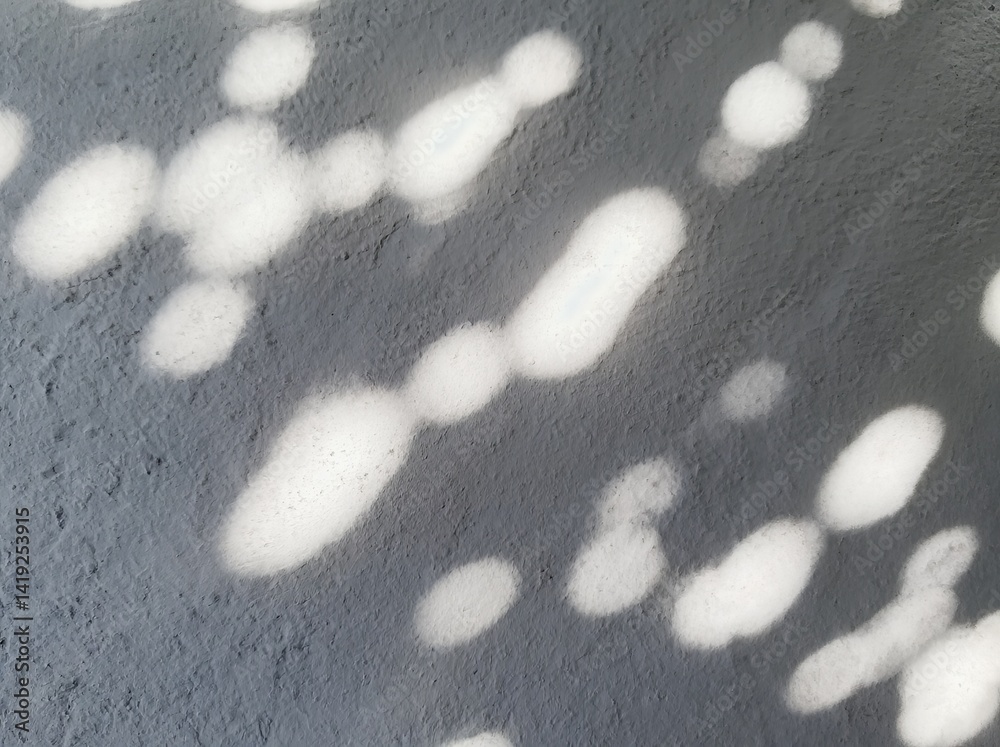 Poster abstract light patterns create a unique backdrop of soft shapes on a gray surface during bright dayl