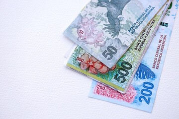 Argentine pesos money bills in big amount lies on white table close up