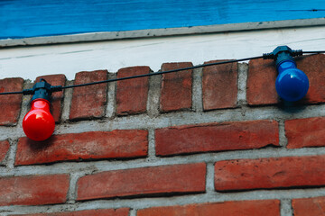 Red and Blue Light Bulbs on Brick Wall – Urban Decorative String Lighting
