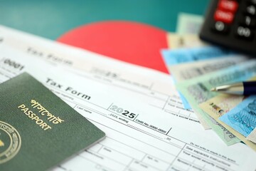 Bangladeshi taka money bills lies on table with pen, calculator, passport and tax forms