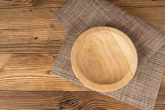 Empty wood bowl on table, plate on wooden table and tablecloth, light rustic dish mockup