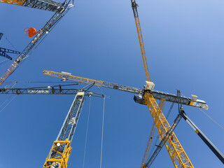 Construction cranes. View from below. Crane used to construct palaces, houses or buildings. Construction site. General contest