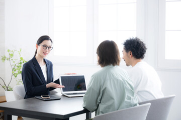 生命保険やローンの相談などを夫婦と営業マンの女性
