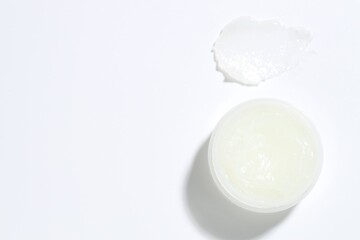 Moisturizing lip balm and jar on white background, top view. Space for text
