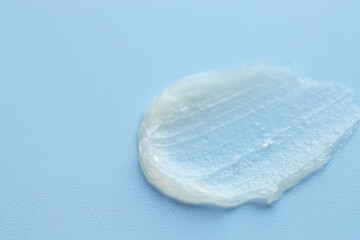 Moisturizing lip balm on light blue background, closeup. Space for text