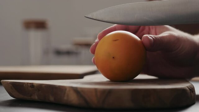 Slow motion man cut lulo fruit on olive wood board with copy space