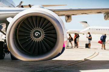 Huge turbofan engine of a modern airplane boarding passengers in airport