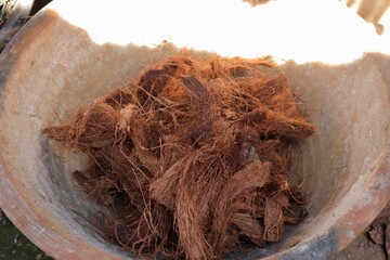 Fiber Nest A basket overflowing with shredded fibrous material in warm earthy tones