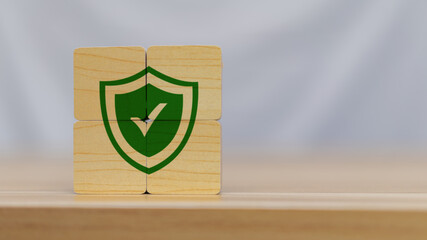 A stack of wooden blocks featuring a green shield and checkmark, symbolizing security, protection,...