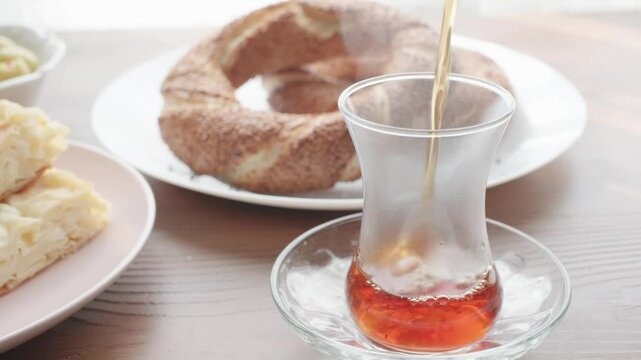 Local Turkish breakfast table Turkish tea, su boregi, green olives and simit bagel	